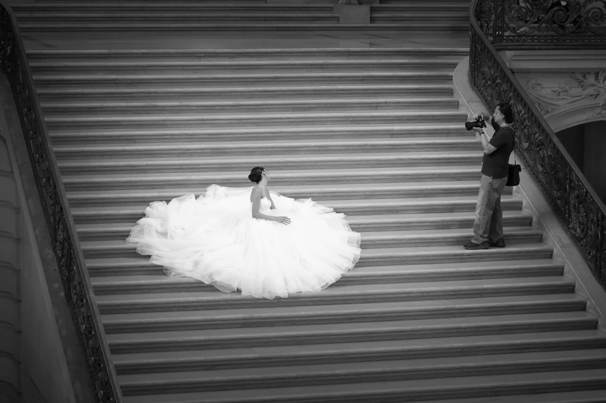 A photographer shooting a bride on a grand staircase