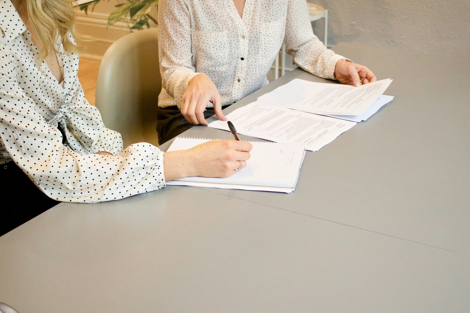 A consultant reviewing work with a client at a table