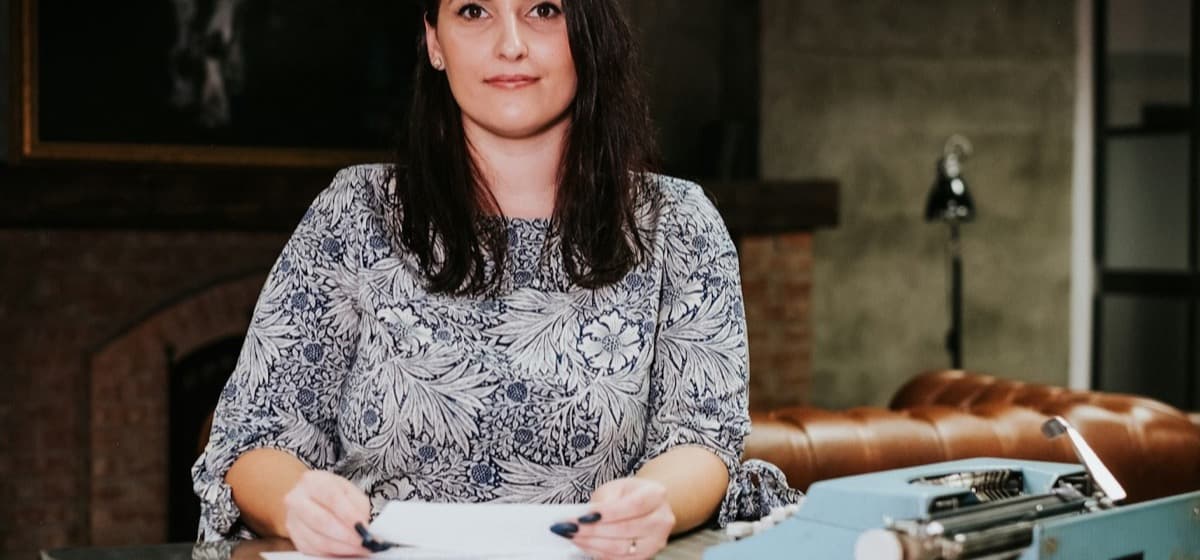 A studio owner seated at her desk with papers in front of her