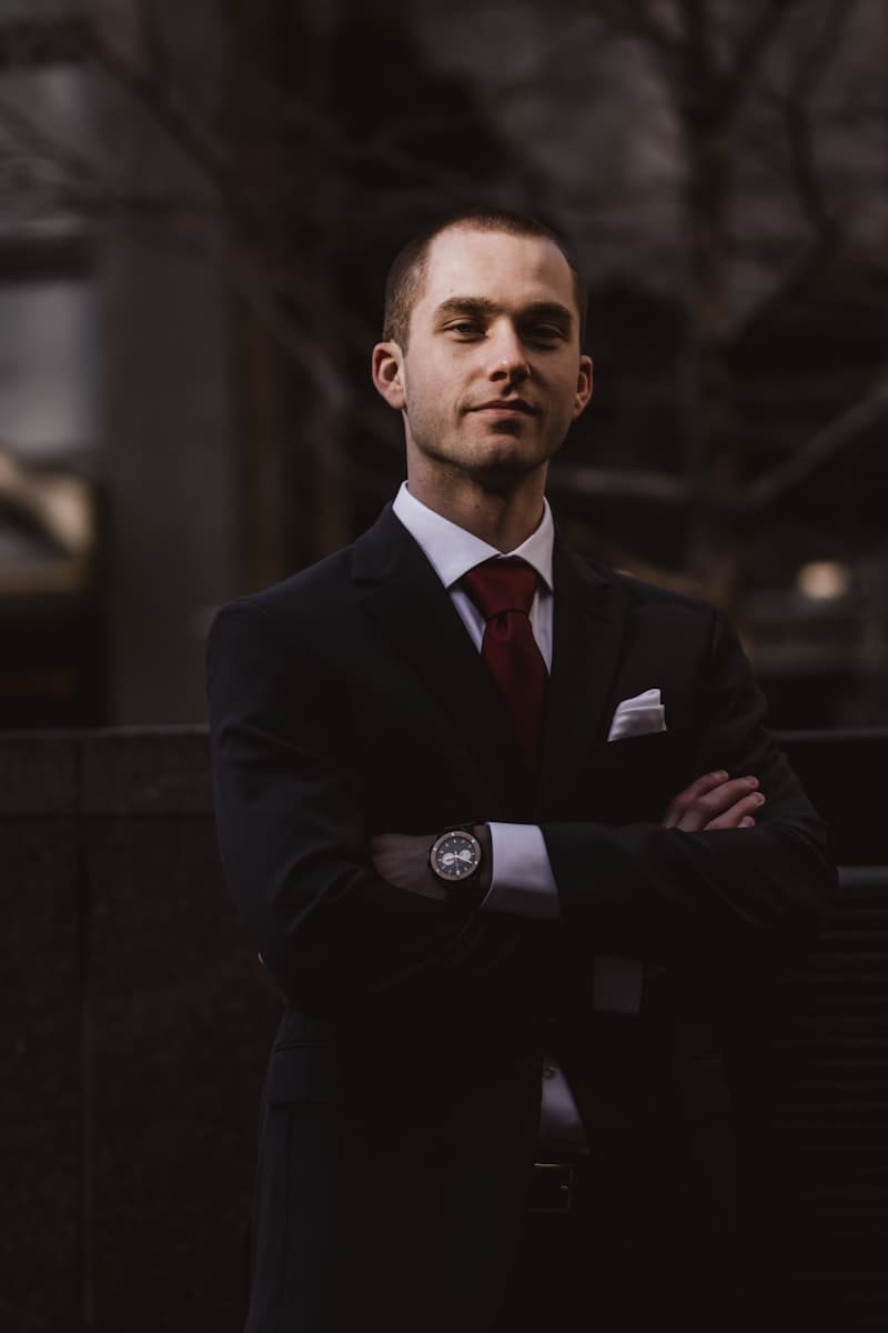 A man in a dark suit jacket in an office corridor