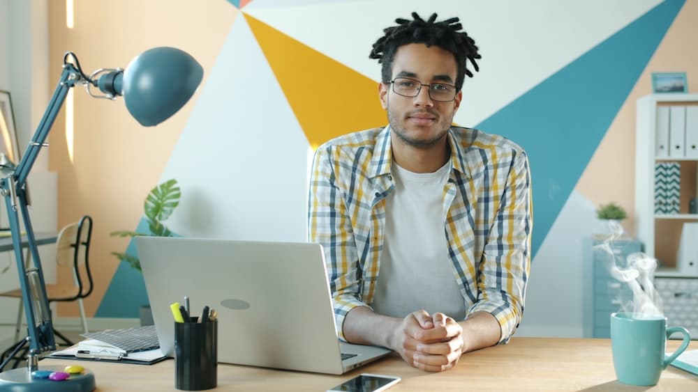 A person starting the day at a desk with a laptop and coffee