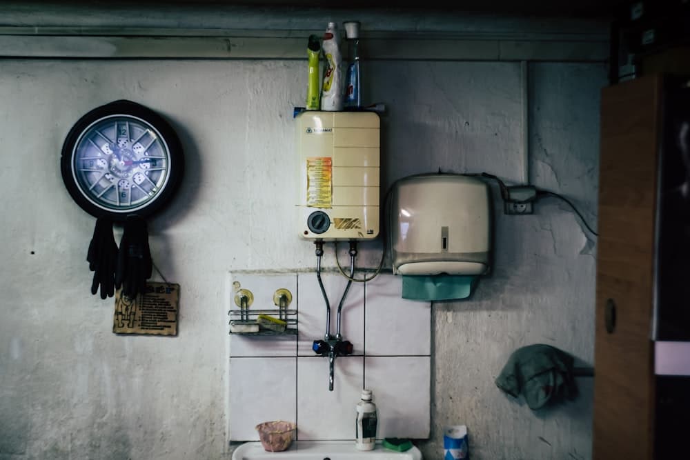 A wall-mounted water heater above a utility sink