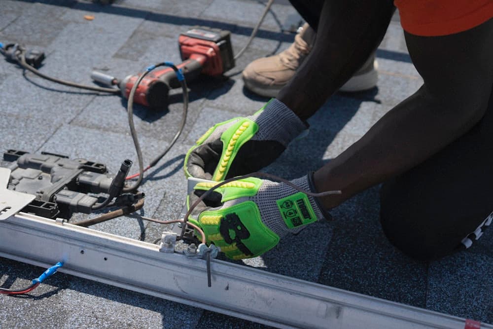 A worker fixing electrical components on a roof