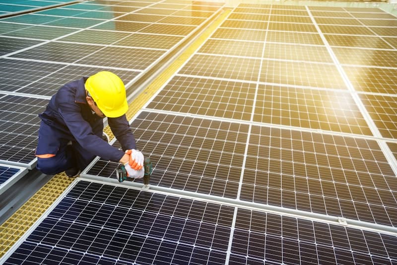 A man in a hard hat working on a solar panel