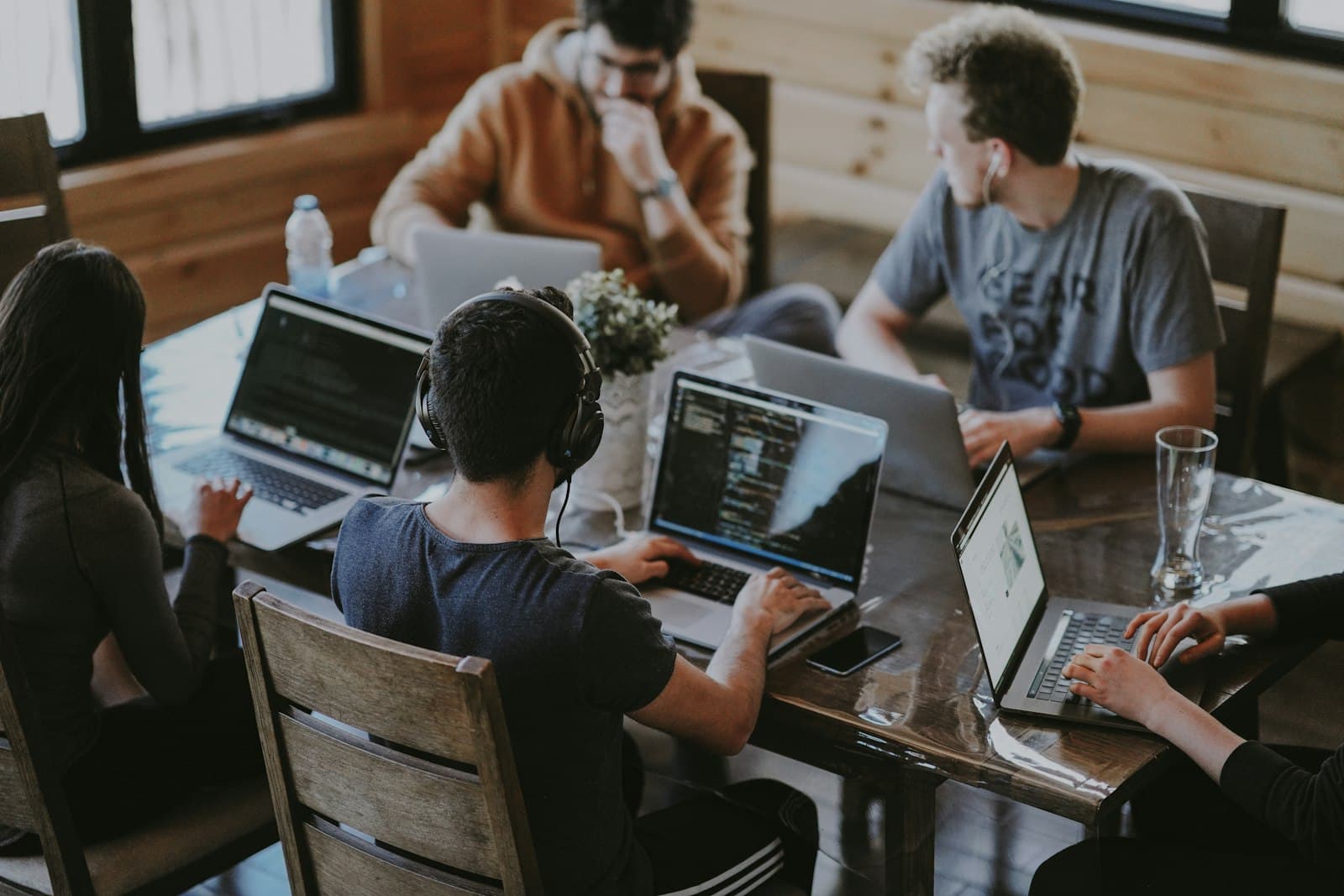 A small team working at laptops around a startup office table