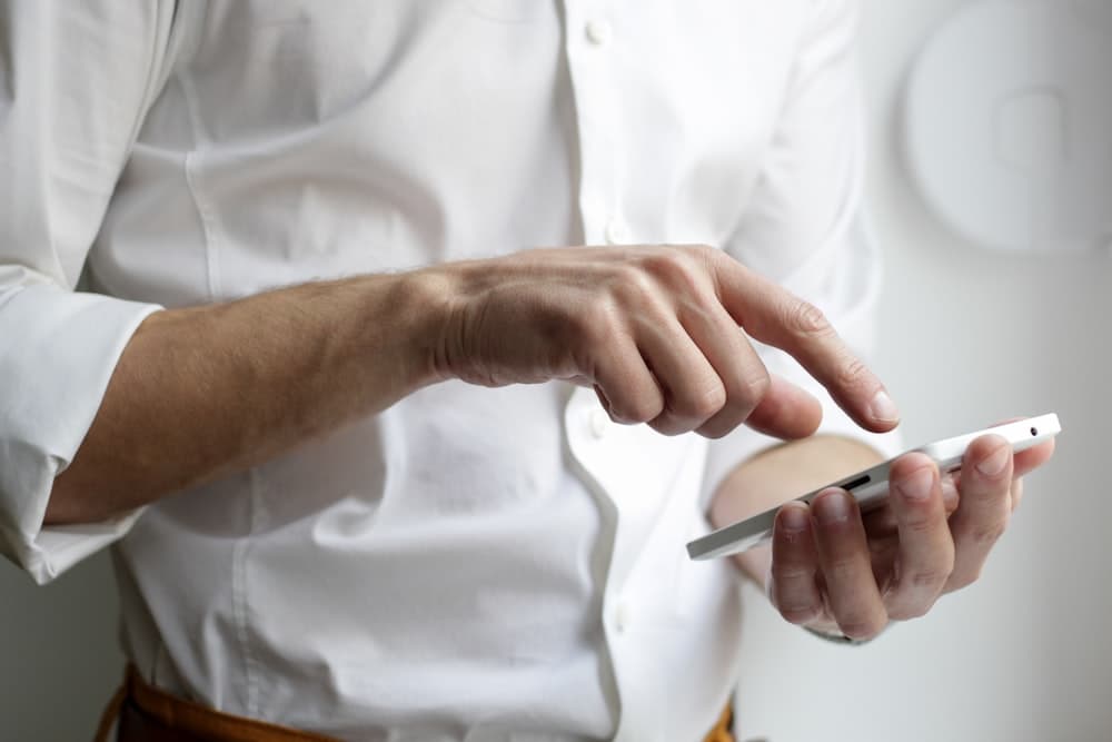 A person checking their phone between meetings in a hallway