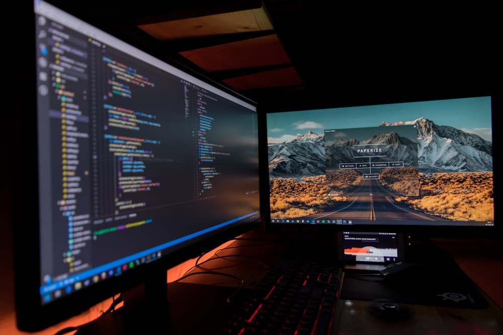 Code on dark monitors in an office late at night