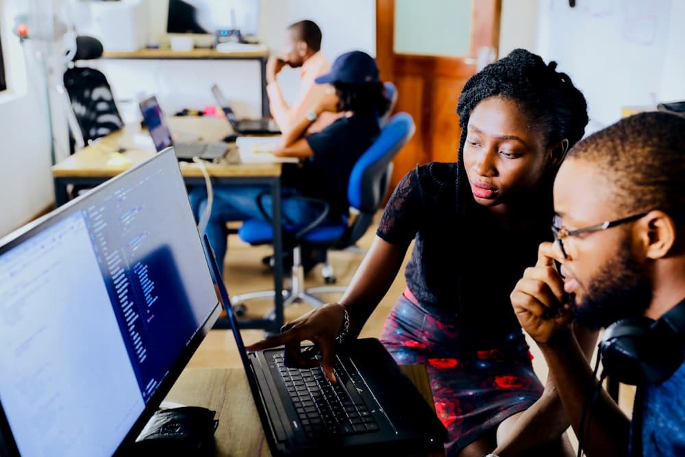 Two developers pairing on code at a shared desk