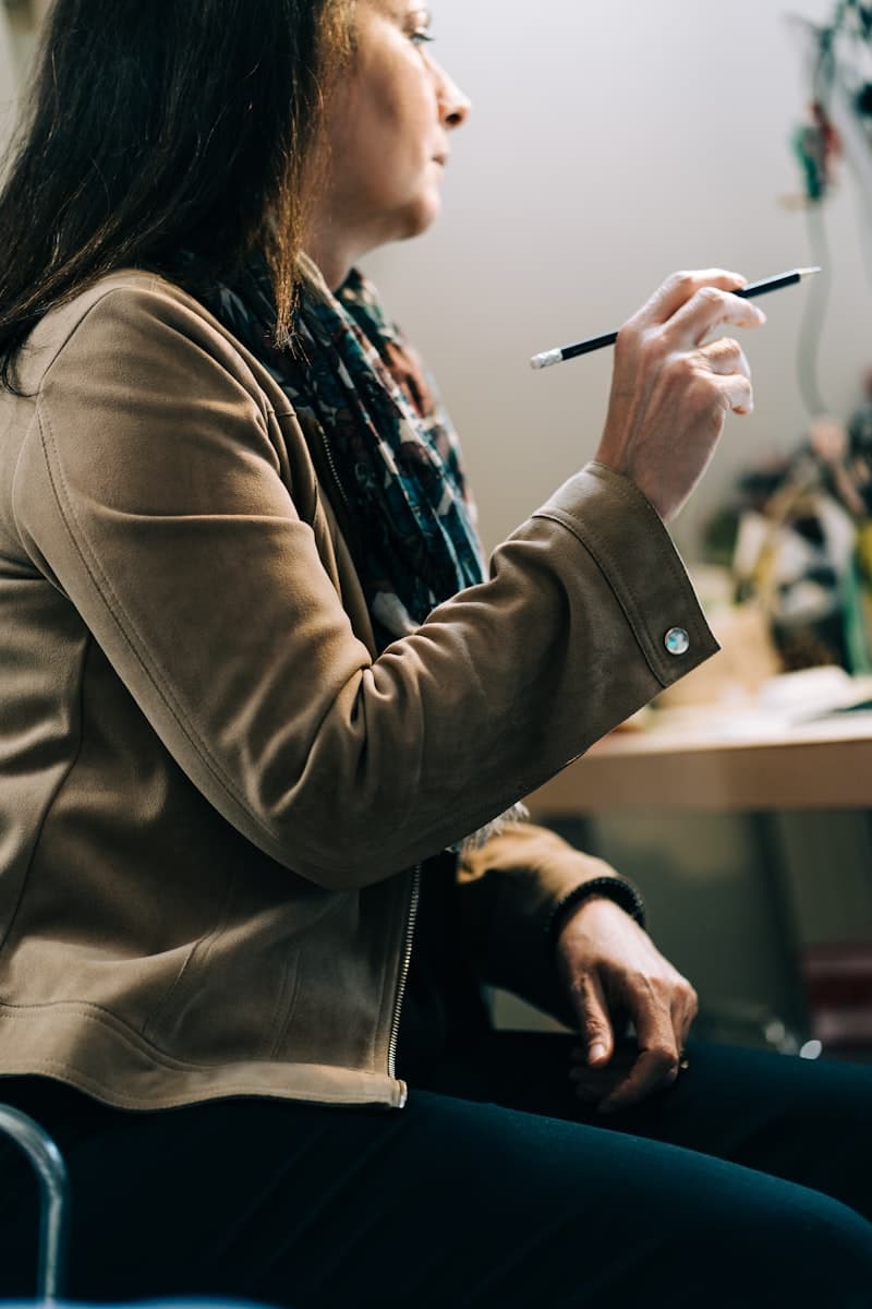 A woman with a pencil thinking through a file at her desk