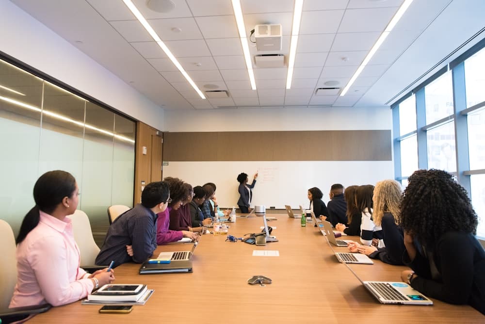 A consultant presenting at a whiteboard in a boardroom