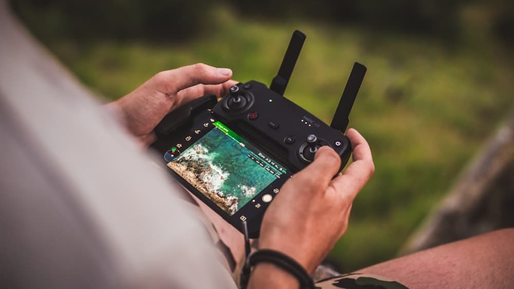Hands on a drone controller during a location shoot