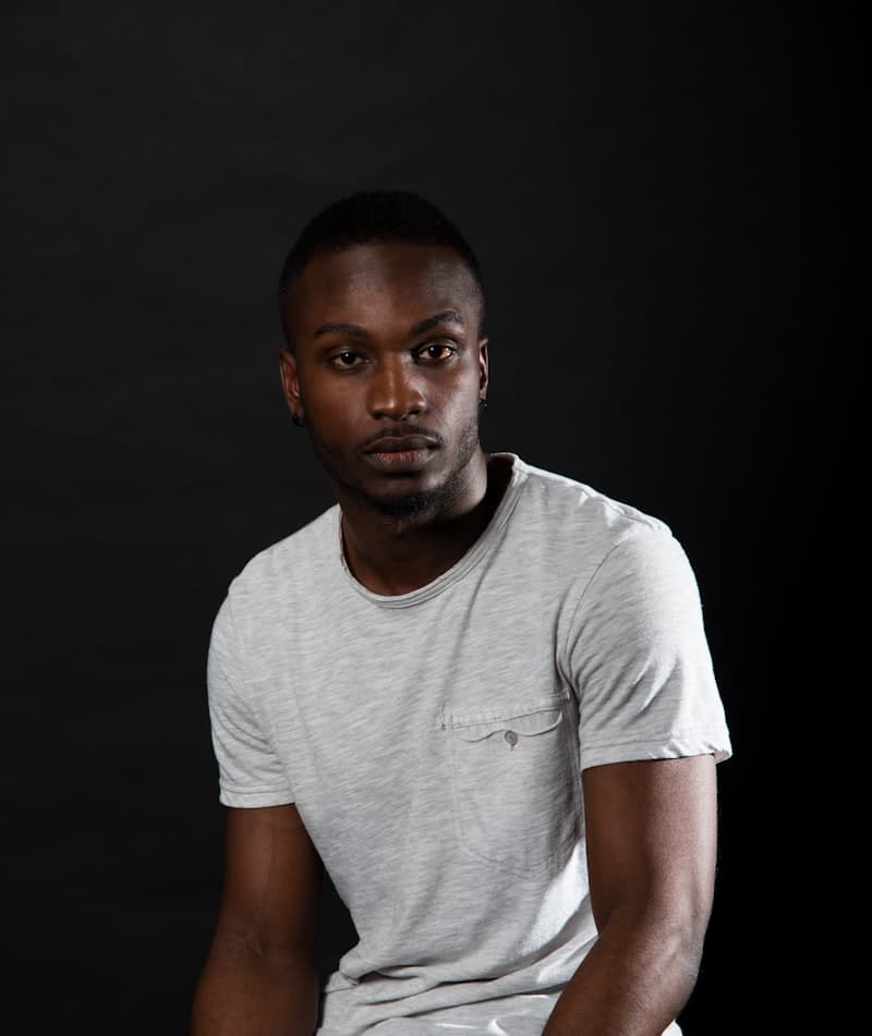 A videographer photographed against a dark backdrop