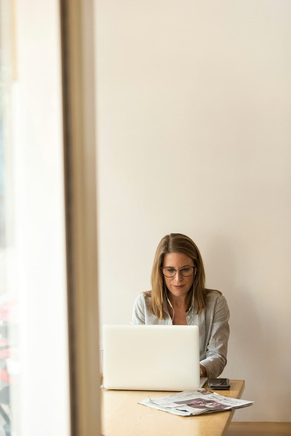 A woman answering inquiries on a laptop at a quiet desk
