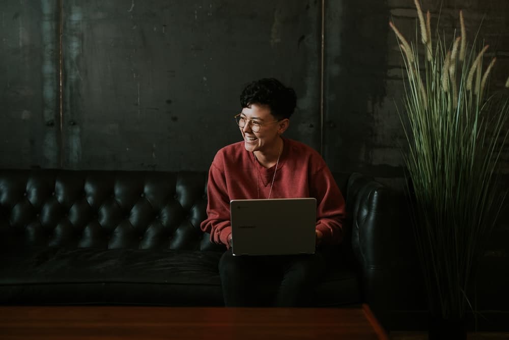 A person building a proposal on a laptop in a dark studio lounge